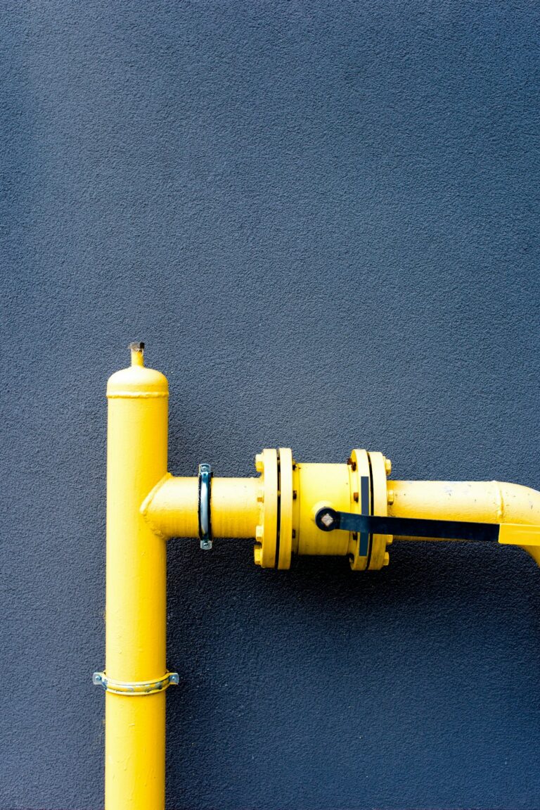 Yellow gas pipe in front of a blue wall